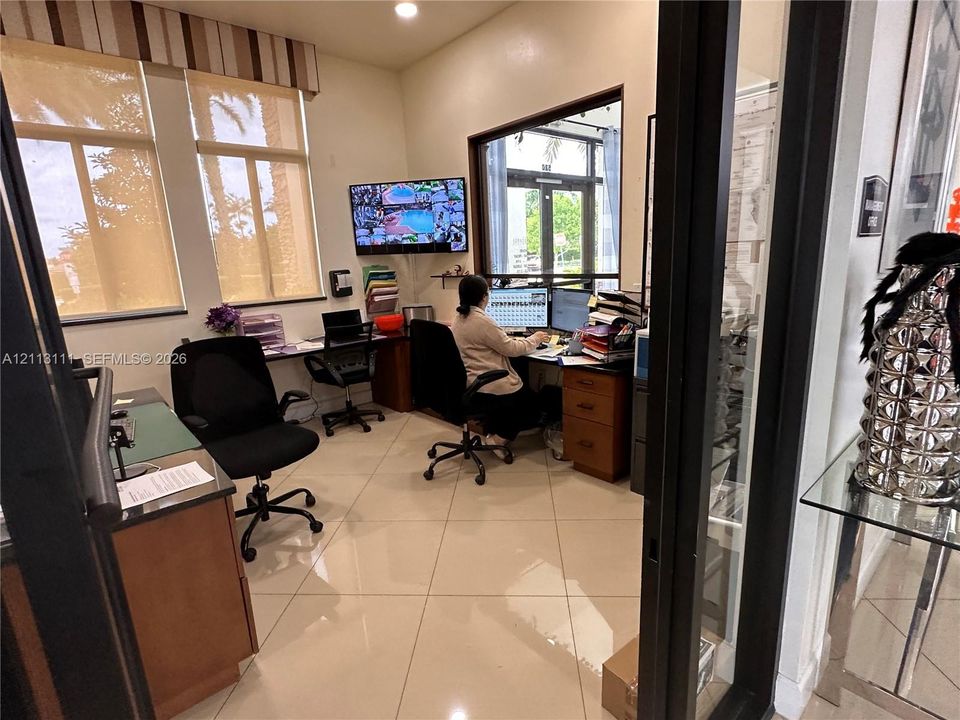 Manager Office space featuring oversized windows, light-toned ceramic tile flooring, and integrated glass-panel interior doors