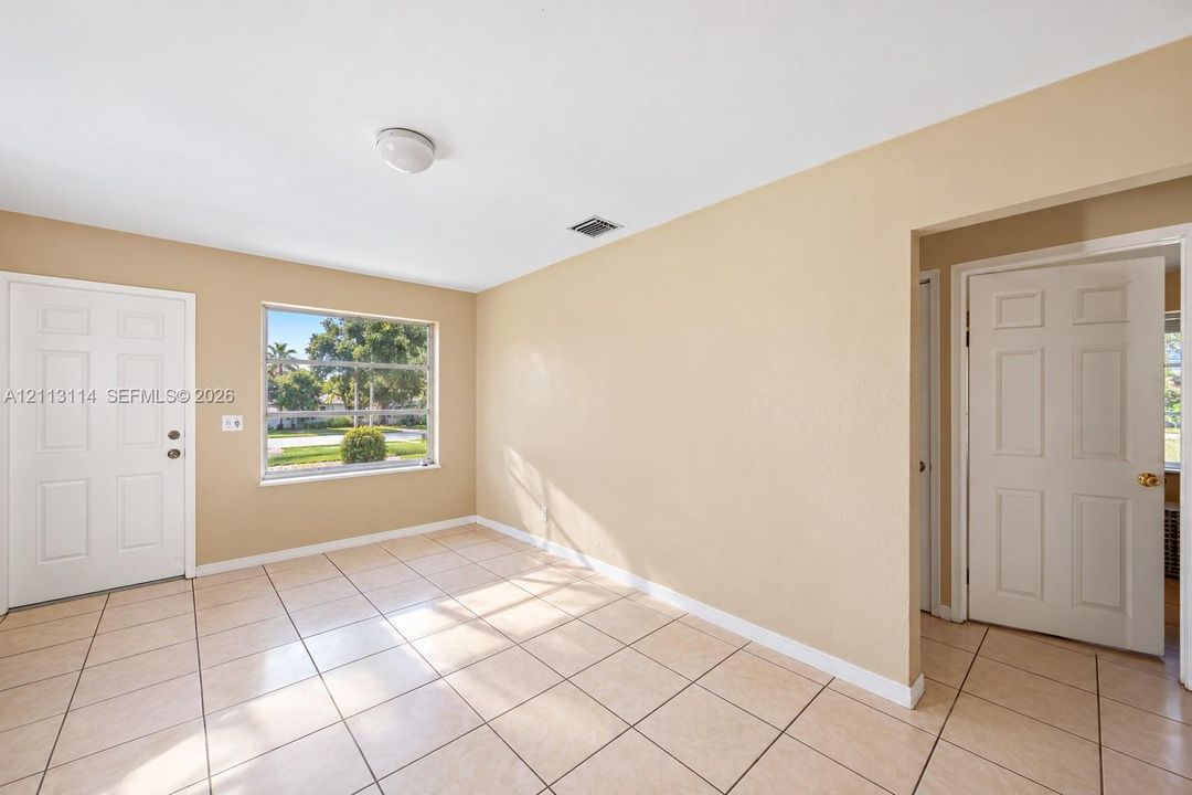 Ceramic tile flooring, neutral wall tones, large window, and paneled doors