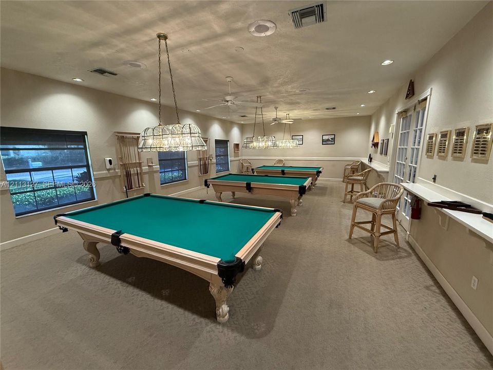 Recreation room featuring multiple billiard tables, recessed lighting, decorative hanging light fixtures, wall-to-wall carpeting, and a built-in counter