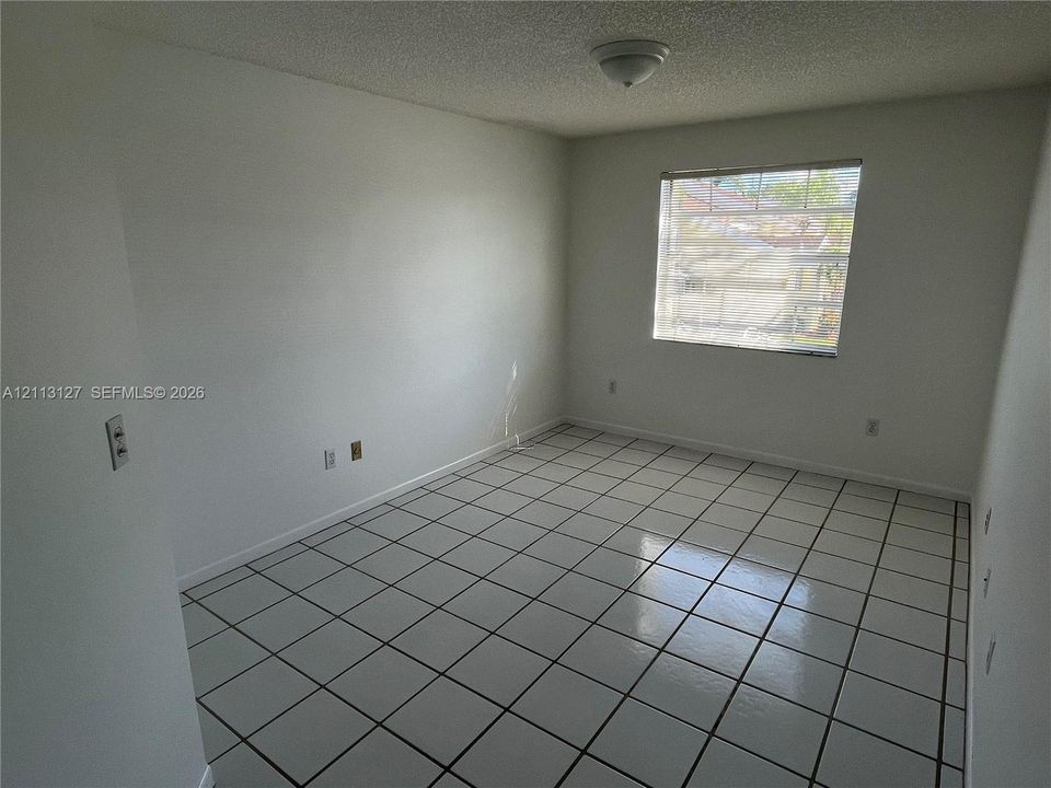 Room featuring ceramic tile flooring, neutral wall paint, and a single-pane window