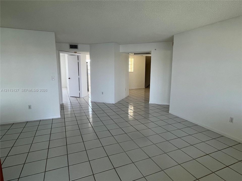 Interior space featuring white tile flooring, smooth ceilings, and interior doorways