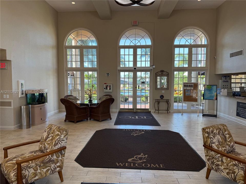 Grand lobby featuring high ceilings, large arched windows with muntin detailing, and tile flooring