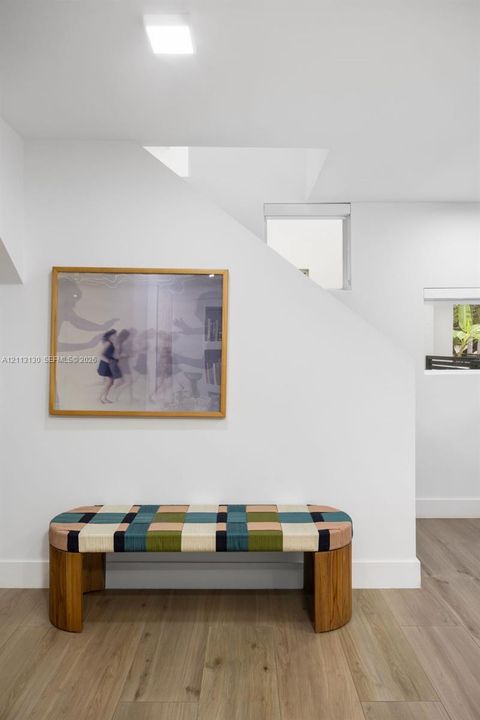 Wood-finish flooring, white walls, recessed ceiling lighting, and fixed windows