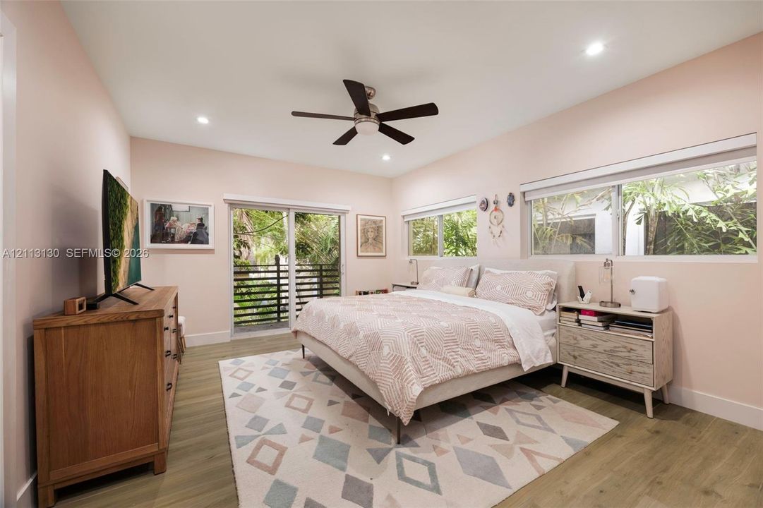 Wood-finish flooring, recessed lighting, ceiling fan, and sliding glass door with exterior balcony access