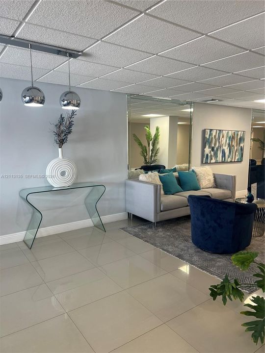 Large-format tile flooring, reflective wall-mounted mirror, and metallic globe pendant lighting