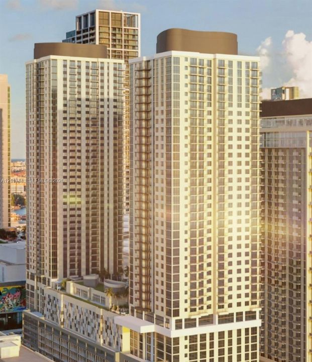 High-rise architectural structure featuring glass-paneled facades, private balconies, a multi-level parking podium, and a rooftop terrace level
