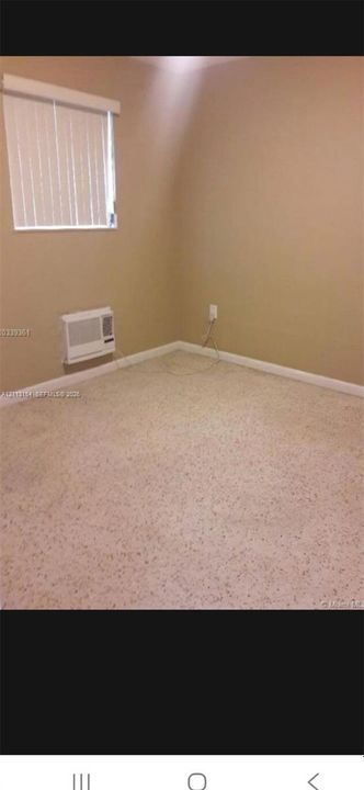 Wall-to-wall carpeting, neutral wall color, and window with white horizontal blinds