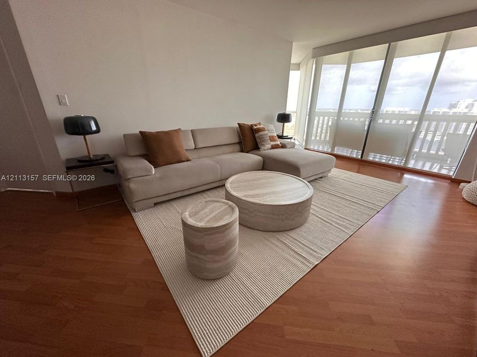 Floor-to-ceiling windows featuring sliding glass doors and wood-finish flooring