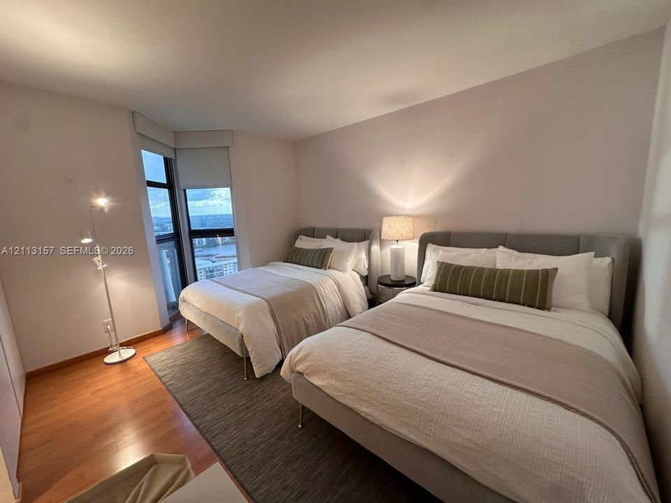 Corner room featuring wood-finish flooring and expansive floor-to-ceiling windows