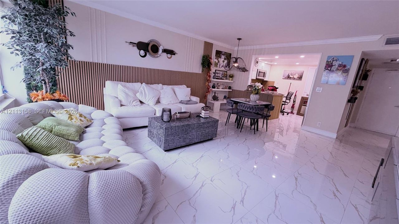 Living area featuring polished tile flooring with stone-patterned veining and floor-to-ceiling vertical wood-slat accent wall paneling