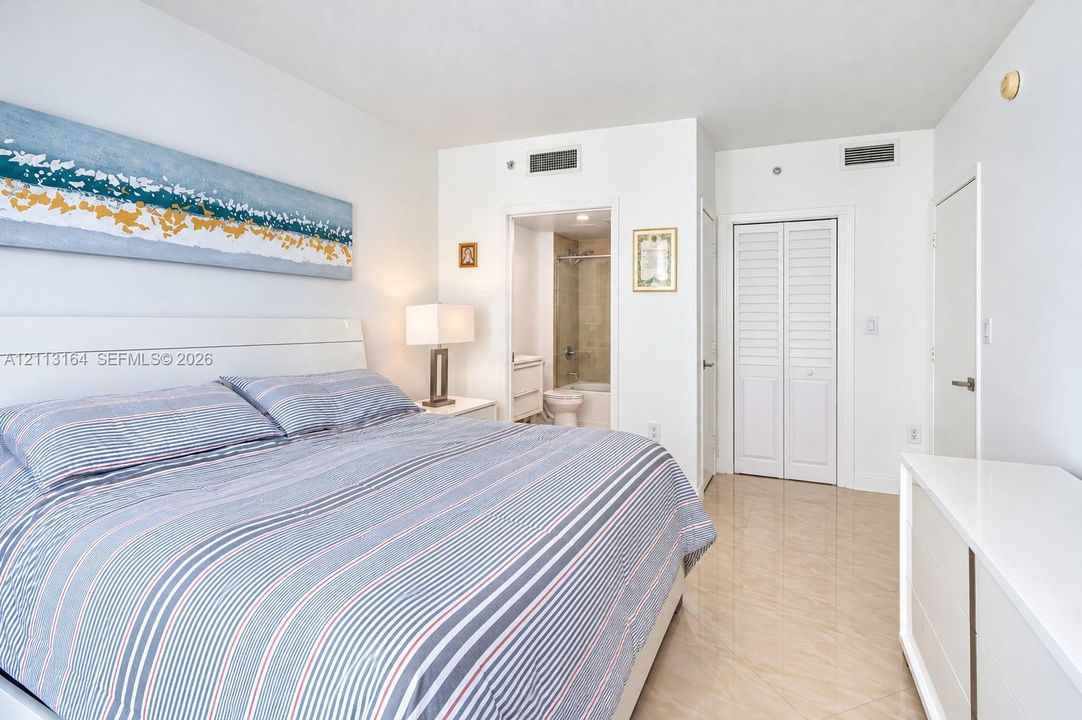 Neutral-tone polished tile flooring, white bi-fold closet doors, and recessed ceiling lighting