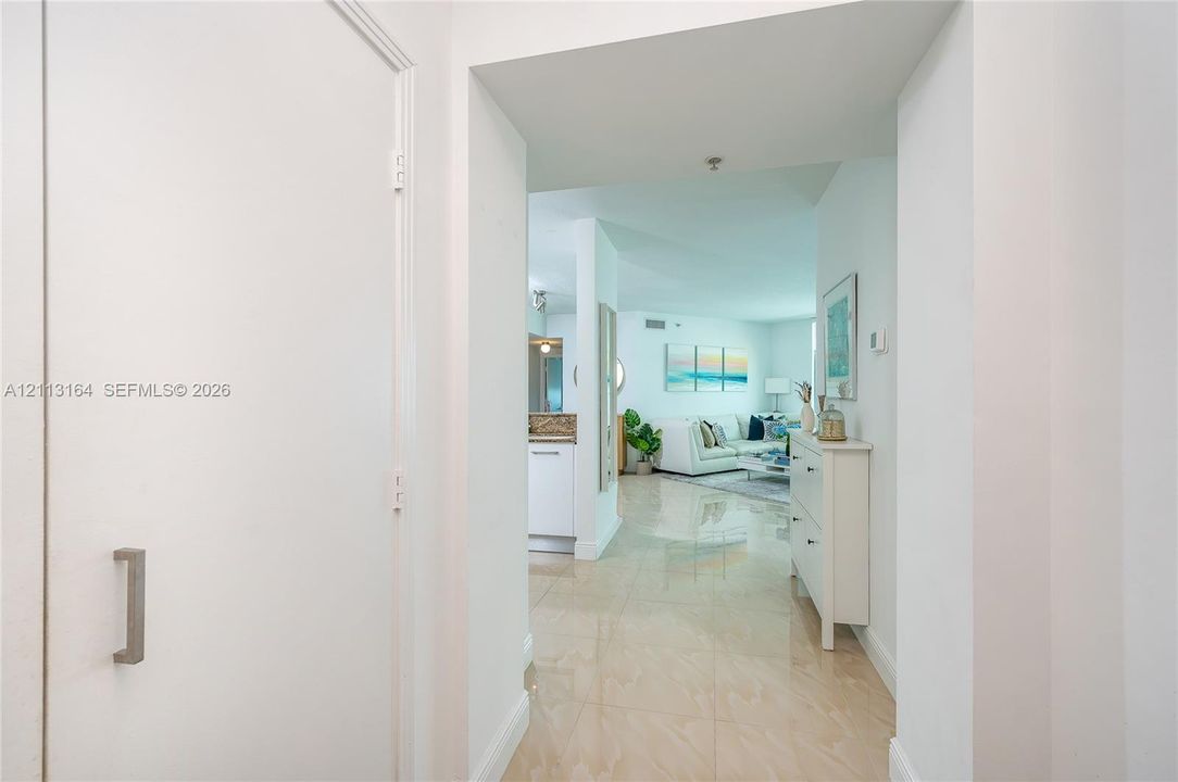 Entryway featuring polished stone-finish tile flooring and a full-height closet with brushed nickel hardware