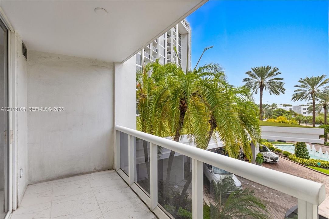 Covered balcony featuring white tiled flooring and a white railing