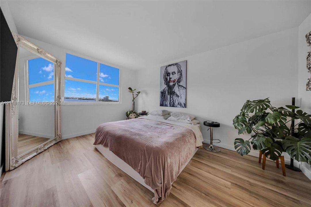 Wood-finish flooring and large multi-pane windows providing natural light and coastal scenery