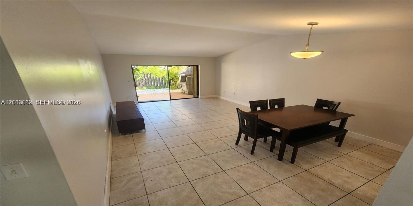 Large-format tile flooring, recessed ceiling lighting, and sliding glass doors with access to an exterior patio area