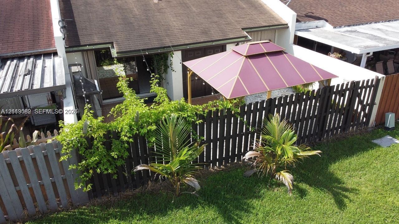 Patio area featuring a paved surface, dark-stained vertical wood fencing, and integrated landscaping
