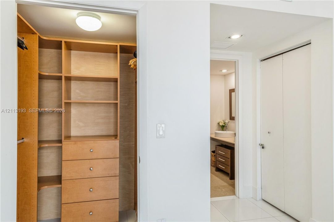 Custom built-in wood-finish shelving and drawer storage with overhead flush-mount lighting