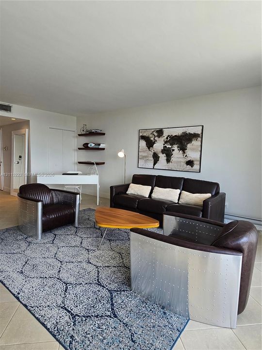 Living area featuring neutral wall paint, tile flooring, and built-in wall shelving