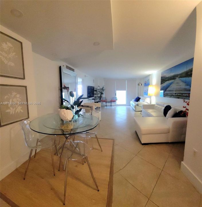 Open-concept interior featuring large-format tile flooring, recessed ceiling lighting, and a distinct wood-finish flooring inlay
