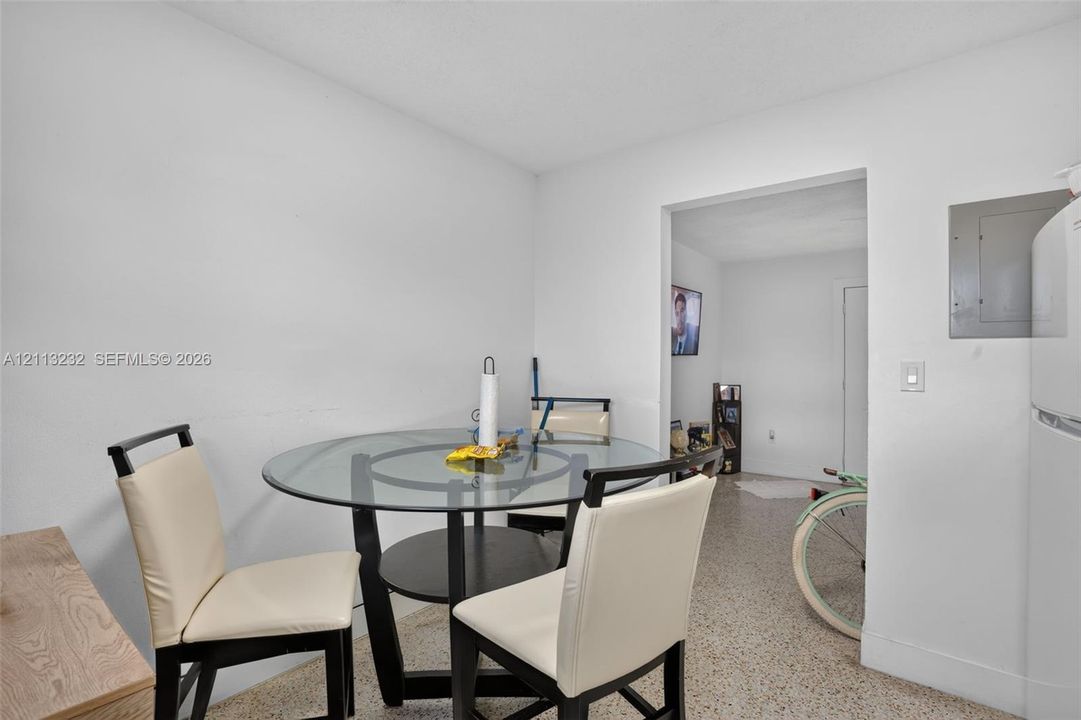 Neutral interior featuring solid surface flooring, a built-in electrical panel, and a standard rectangular doorway