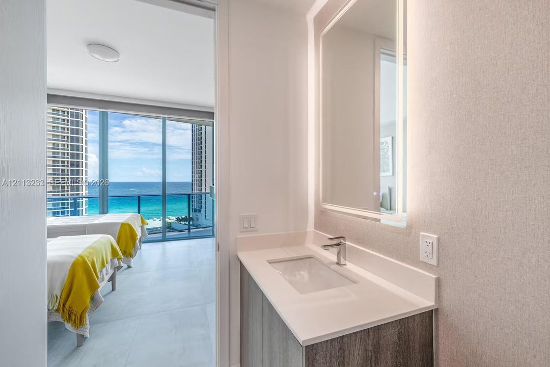 Modern vanity featuring a rectangular integrated sink, quartz countertop, and a wall-mounted LED mirror