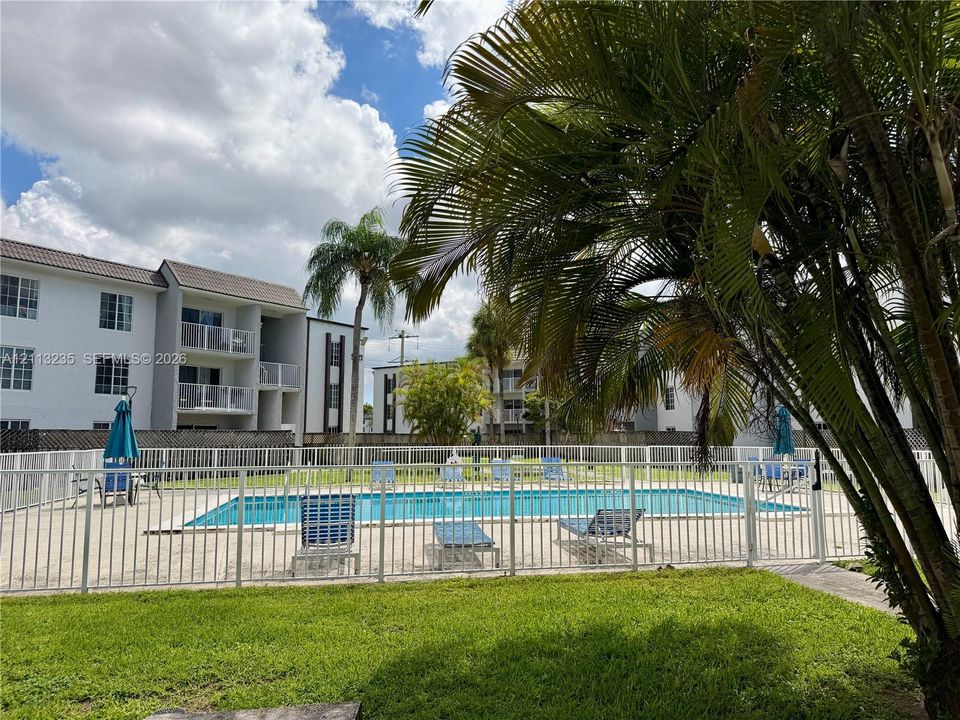 Swimming pool with perimeter metal fencing and manicured lawn area