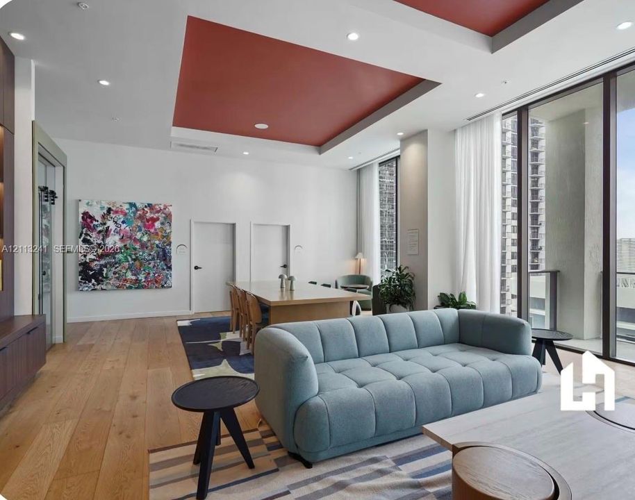 Open-concept space featuring recessed ceiling detailing with accent color, full-height floor-to-ceiling windows, recessed lighting, and wide-plank wood-finish flooring