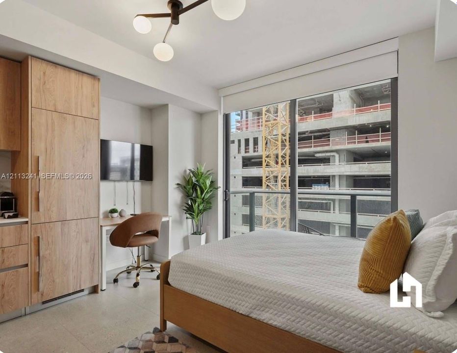 Floor-to-ceiling windows, modern wood-finish cabinetry with integrated appliances, light-toned tile flooring, and a contemporary multi-globe ceiling light fixture