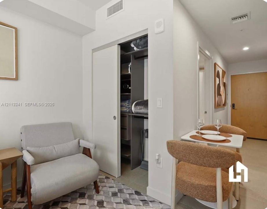 Built-in closet featuring floor-to-ceiling dark-toned shelving, hanging rods, and a sliding door