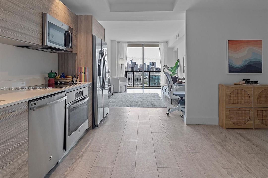 Kitchen featuring wood-finish cabinetry, stainless steel appliances, solid-surface countertops, and wood-finish flooring