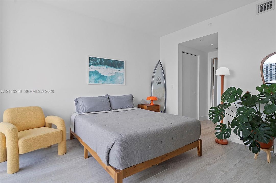 Neutral-toned wood-finish flooring, crisp white walls, and recessed ceiling lighting