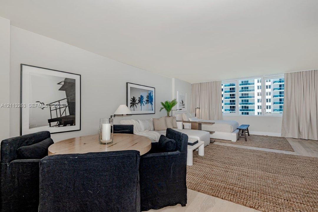 Open-concept interior featuring light-toned wood-finish flooring and expansive floor-to-ceiling windows