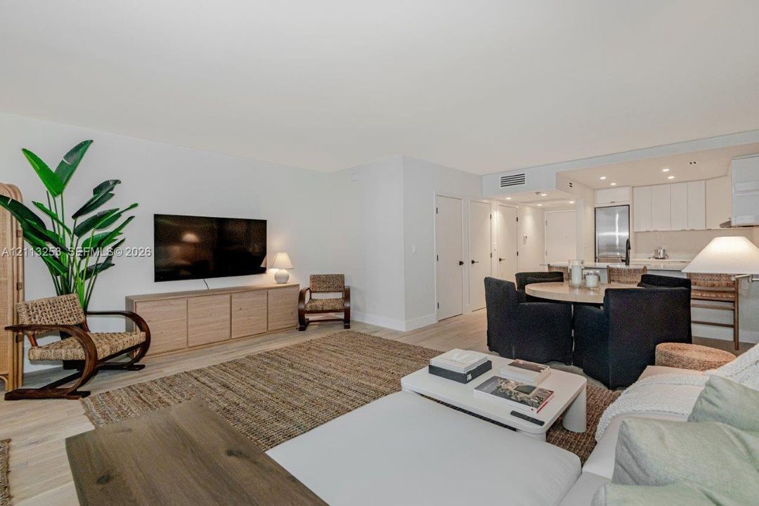 Open-concept floor plan featuring light-toned wood-finish flooring, recessed lighting, and kitchen cabinetry with integrated stainless steel appliances
