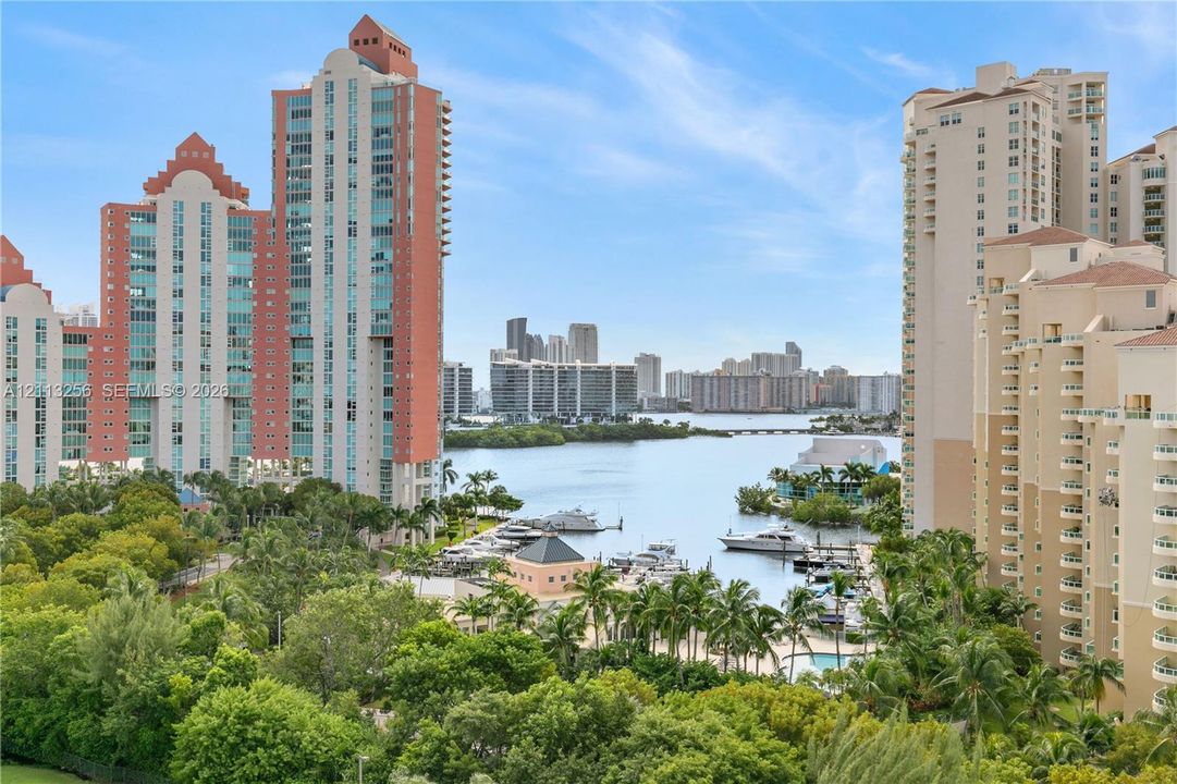 Panoramic views of marina, ocean and bay waters, and a distant cityscape featuring mature tropical landscaping