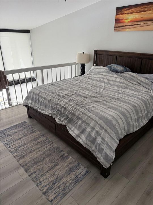 Wood-finish flooring, white railing enclosure, and floor-to-ceiling windows