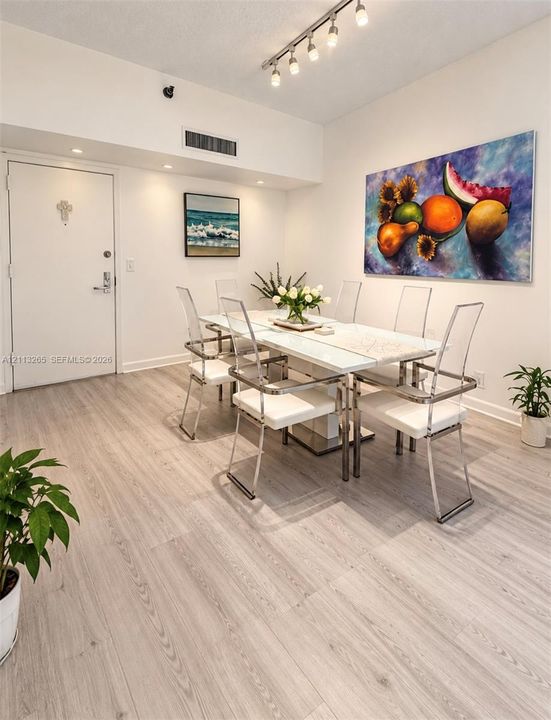 Wood-finish flooring, recessed ceiling lighting, and a multi-bulb track light fixture
