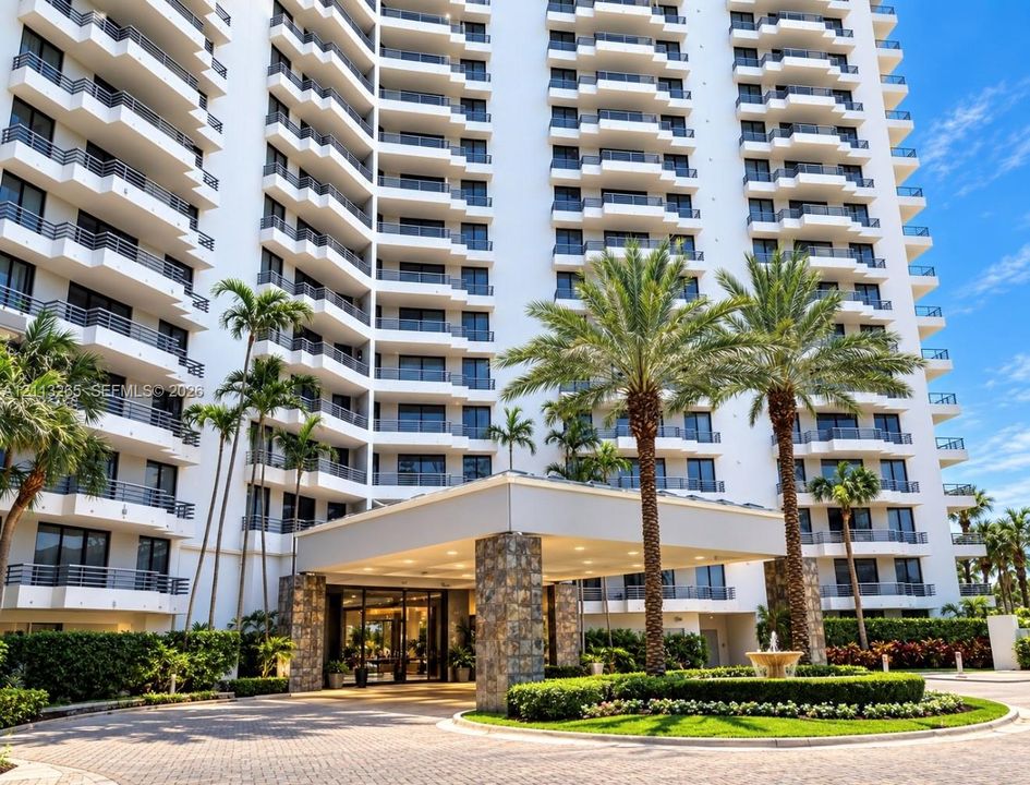 High-rise architectural exterior featuring a stone-clad porte-cochère, multi-level private balconies, paved circular motor court, mature palm trees, and a decorative fountain