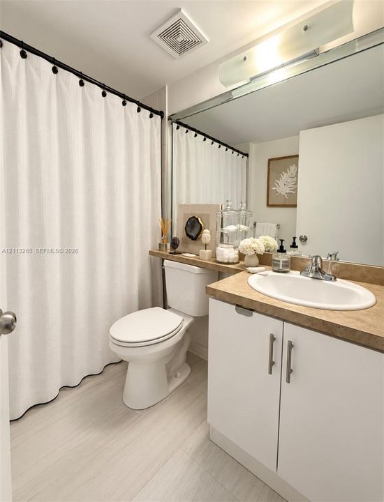 Bathroom featuring a vanity with white cabinetry, a neutral-toned countertop, and an integrated oval sink