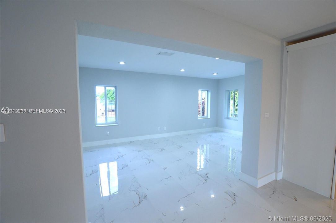 Polished stone-finish flooring, recessed lighting, and multiple windows with white frames