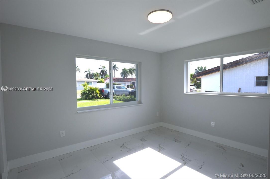 Neutral-toned interior featuring large-format stone-finish tile flooring and dual sliding windows