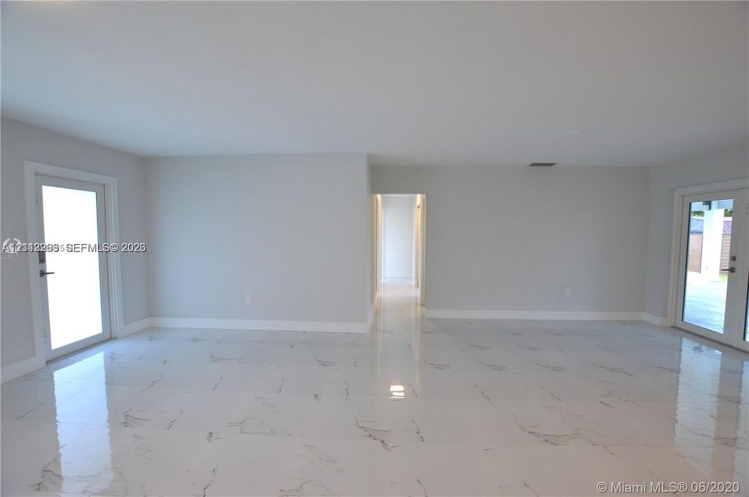 Open interior space featuring polished stone-finish flooring and two glass-paned entry doors