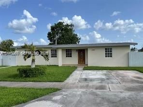Single-story residence featuring a smooth stucco exterior, multi-pane windows, a centered wood-finish front entry door, and a concrete driveway