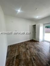 Wood-finish flooring, white walls, recessed ceiling lighting, built-in wardrobe, and glass-paneled exterior door