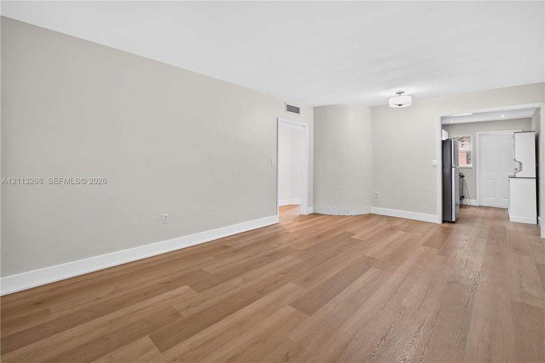 Interior space featuring wood-finish flooring, neutral wall paint, and overhead drum lighting