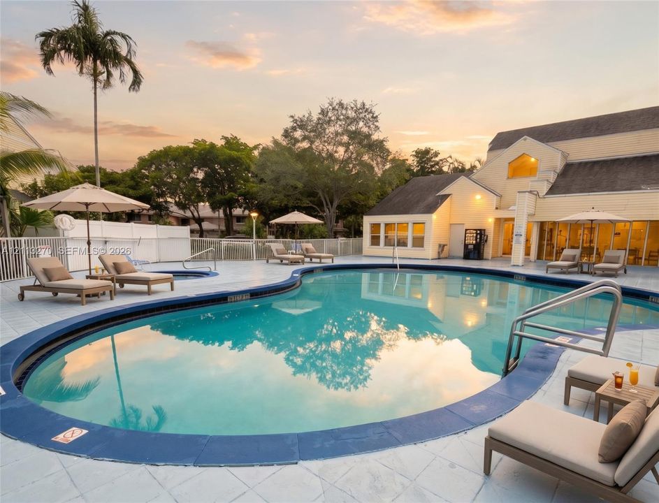In-ground pool with perimeter tile, integrated spa, and expansive paved deck area