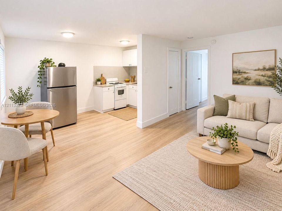 Kitchen area featuring white cabinetry, integrated stainless steel refrigerator, and wood-finish flooring throughout