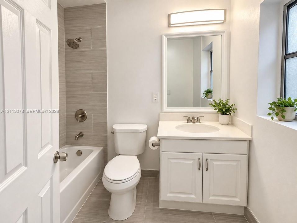 Bathroom featuring a white vanity with a solid-surface countertop, an integrated sink, polished chrome fixtures, a tiled tub surround, and ceramic floor tiling