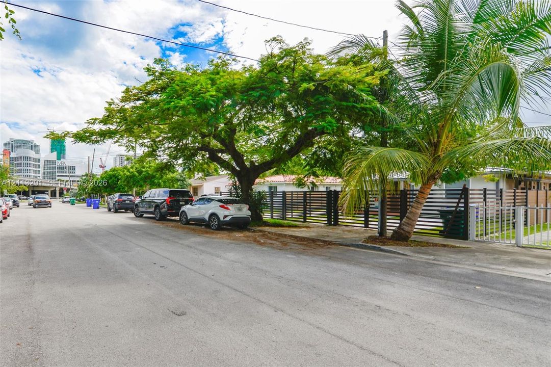 Property exterior featuring horizontal privacy fencing, mature trees, and a concrete driveway
