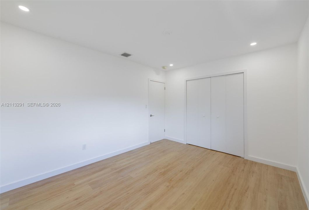 Interior room featuring wood-finish flooring, recessed lighting, and a double-door closet