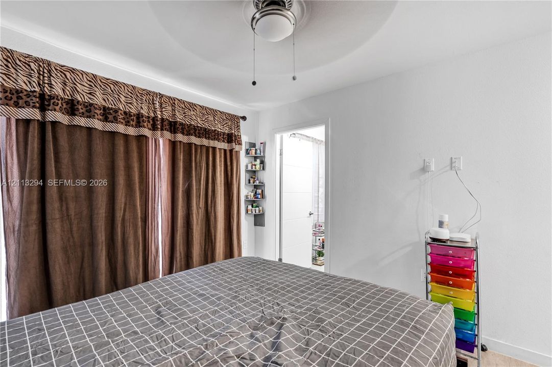 Ceiling-mounted light fixture with integrated fan, wall-mounted corner shelving unit, and recessed doorway